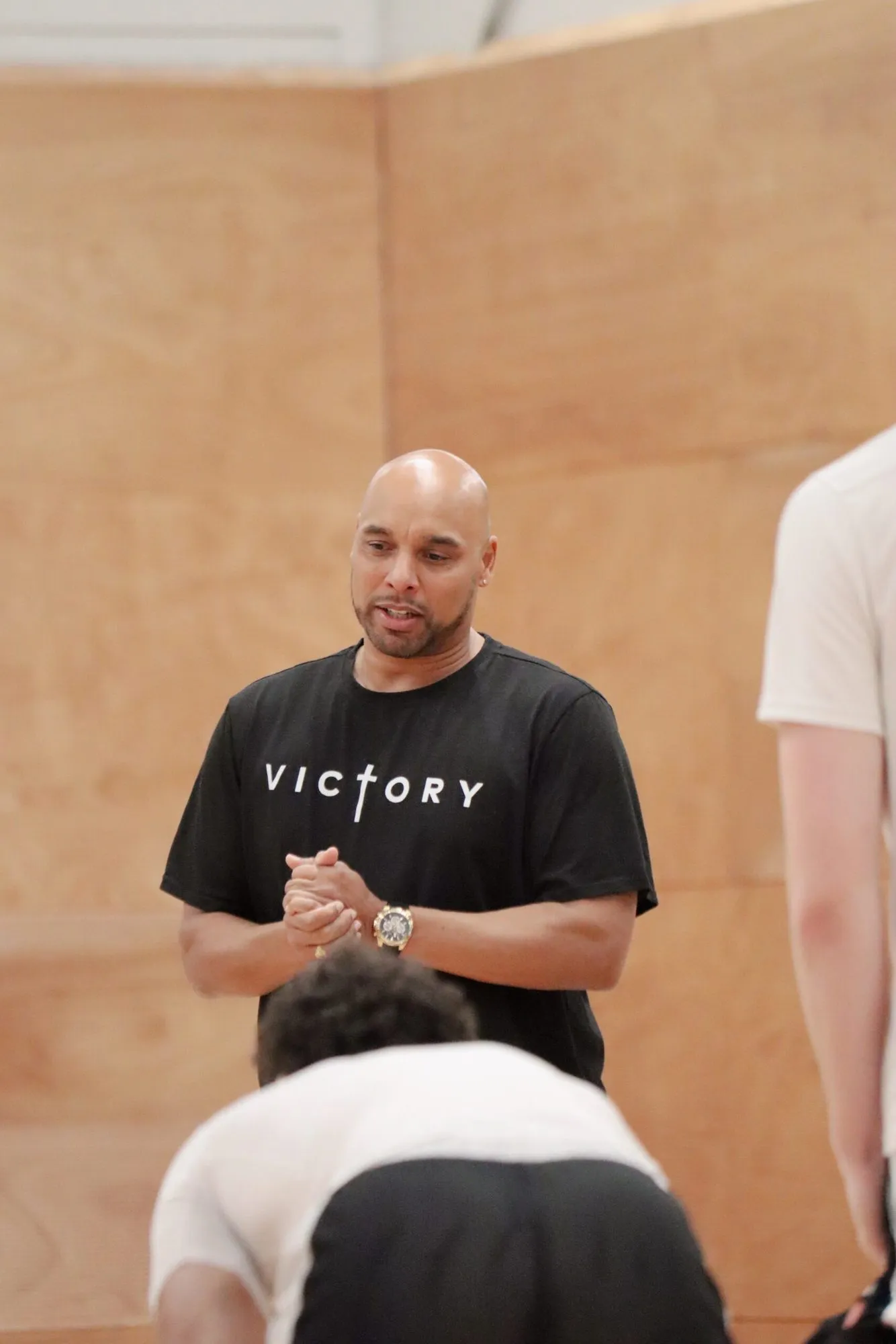 Coach geeft uitleg aan een groep spelers in de zaal