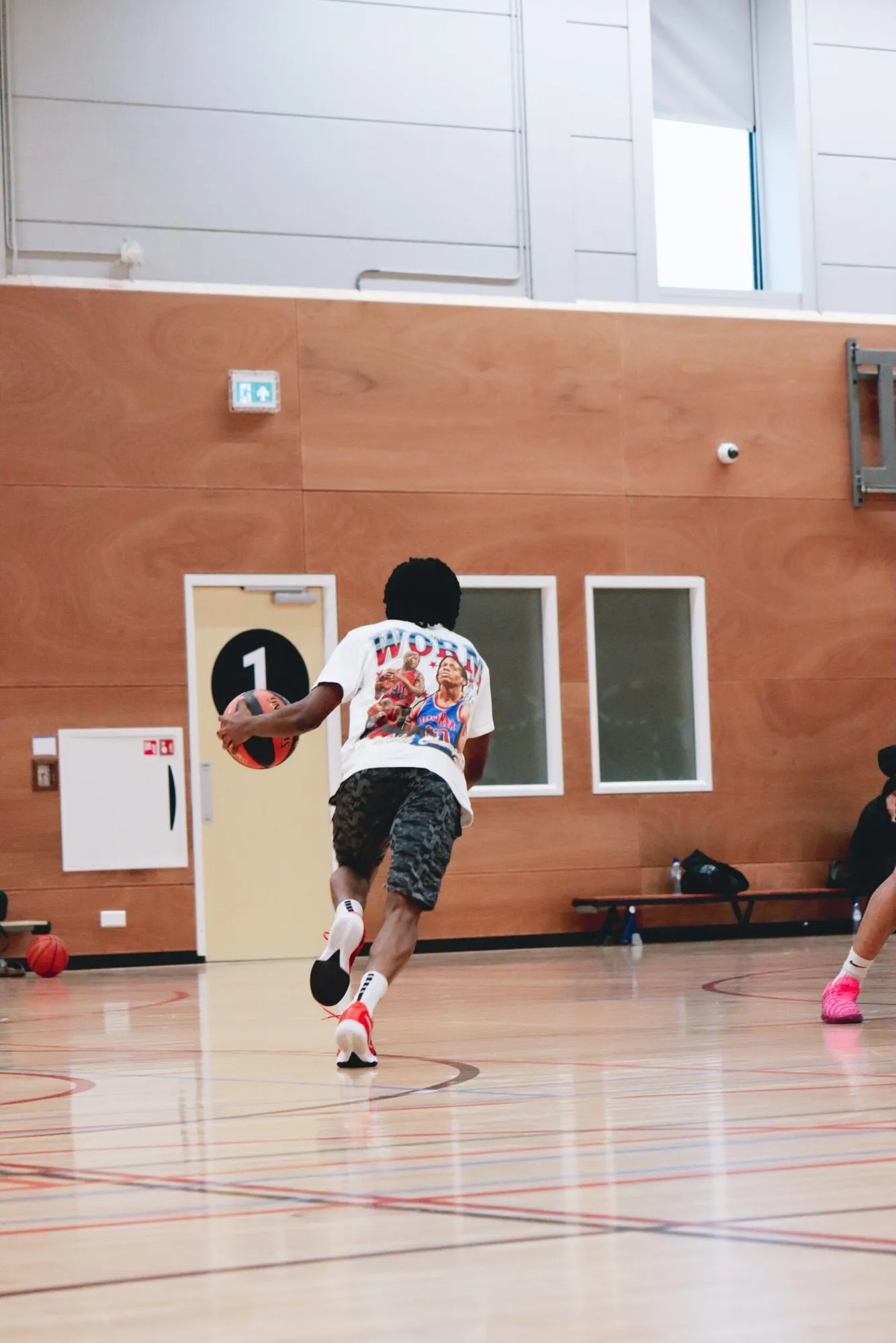 Speler dribbelt met de bal naar de basket