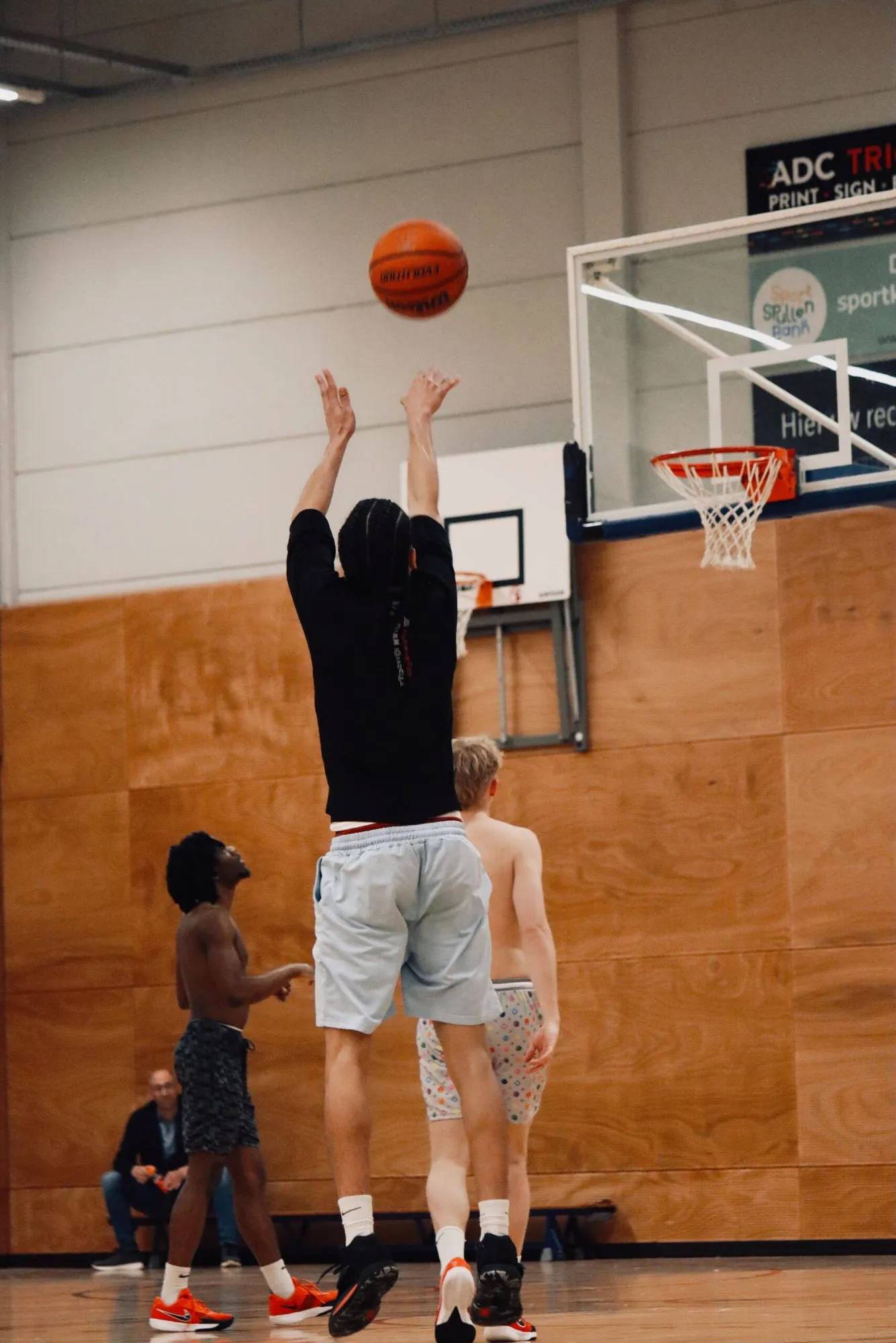 Speler neemt een jump shot bij de basket