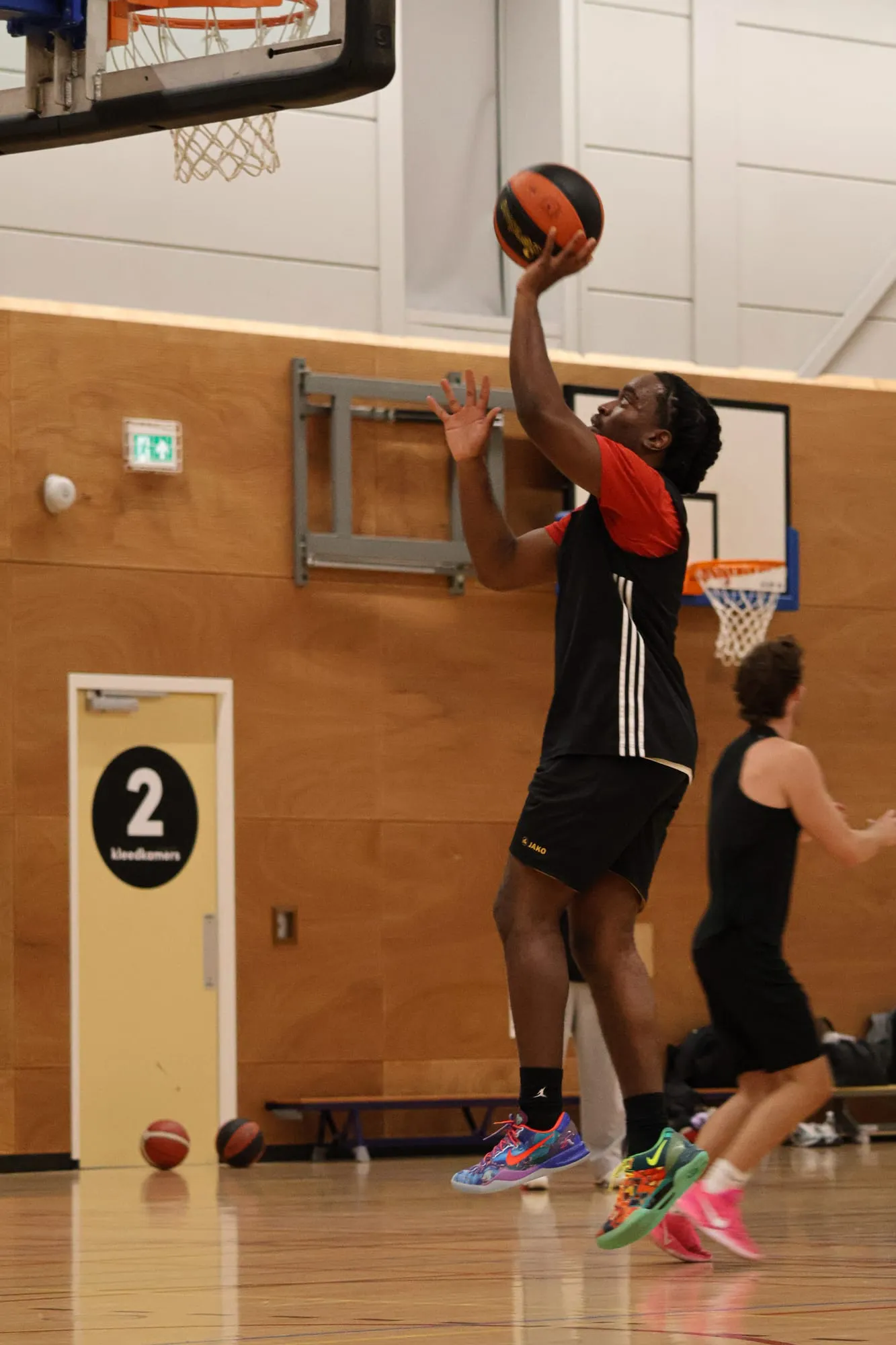 Speler schiet vanaf korte afstand onder de basket